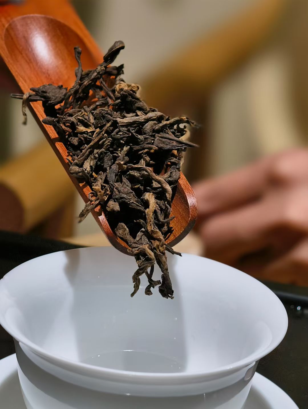 茶铲中的干茶与白瓷茶杯特写